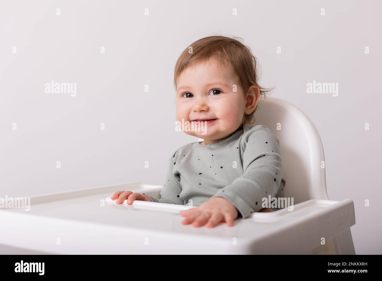 cute baby sitting in high chair, card, banner, space for text. High