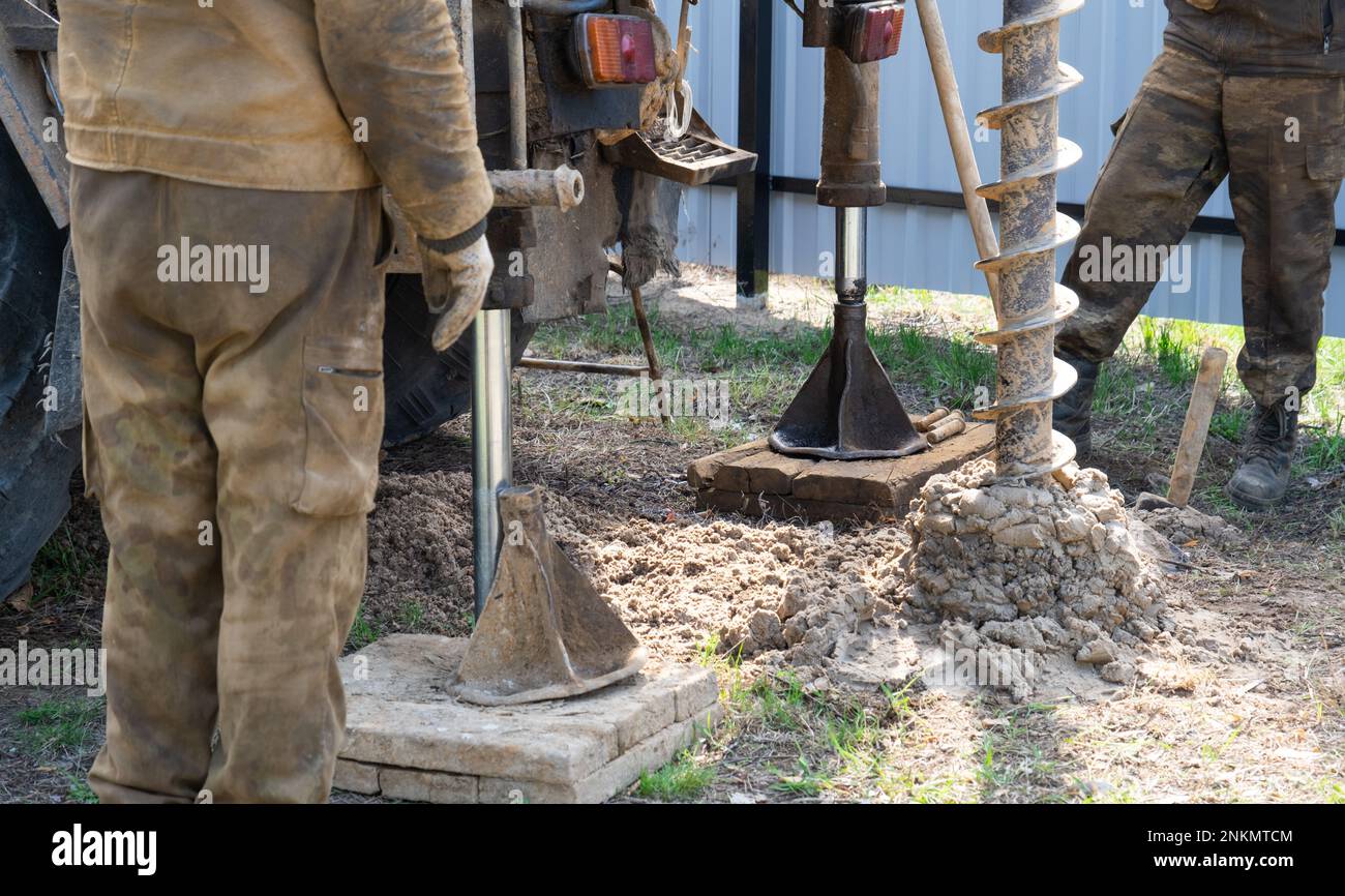 Team of workers with drilling rig on car are drilling artesian well for