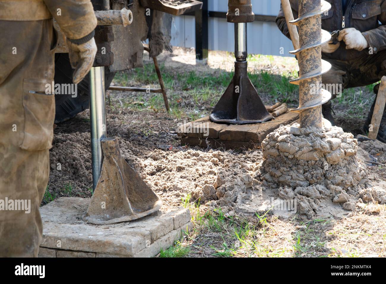 Team of workers with drilling rig on car are drilling artesian well for