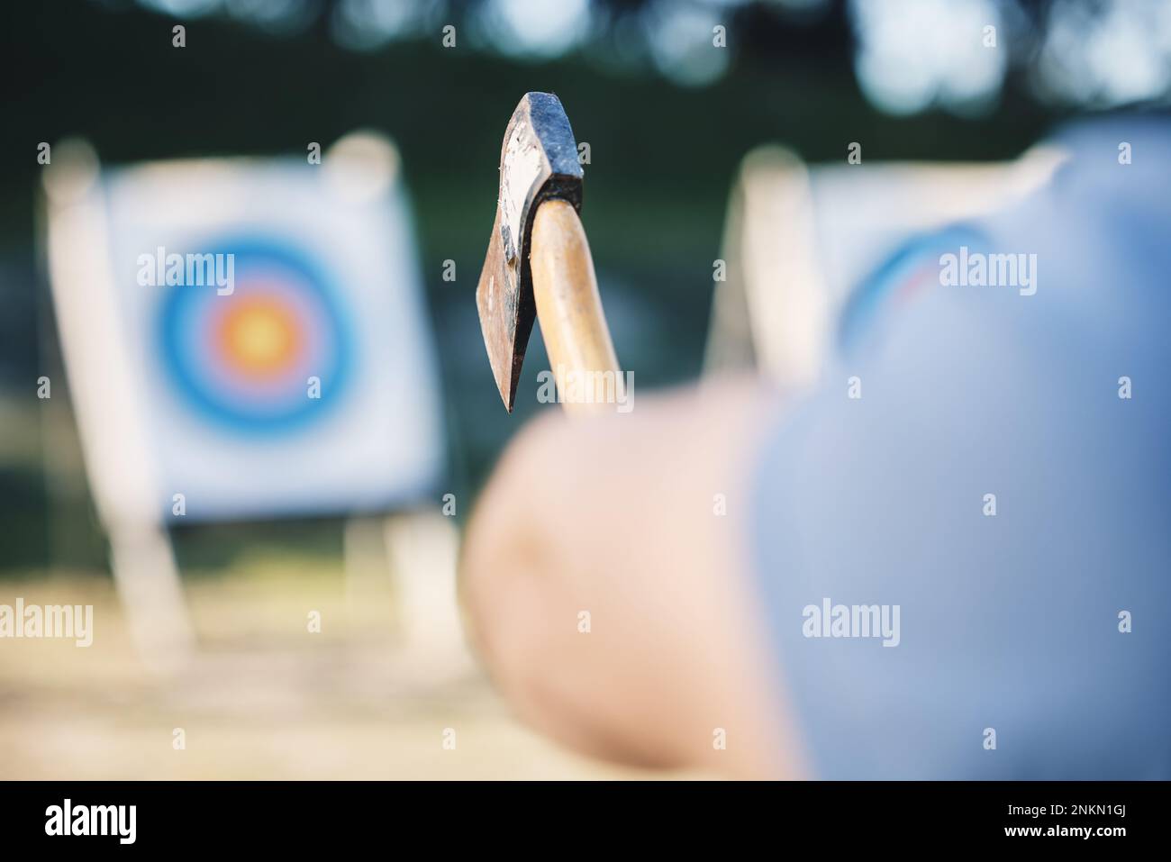 Man throwing axe at sports range, archery training or practice with