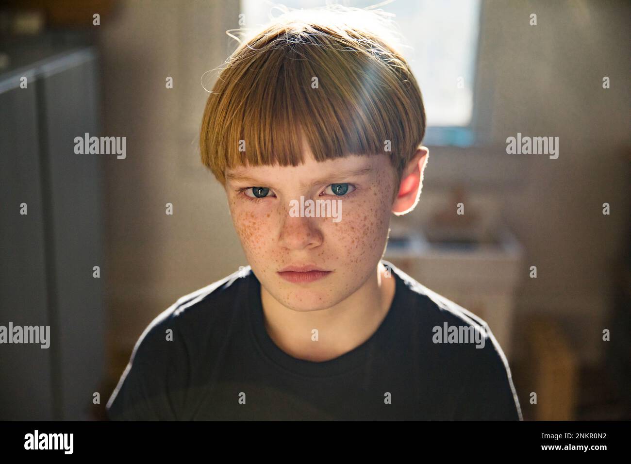 Portrait of boy with red hair and freckles looking towards camera Stock Photo