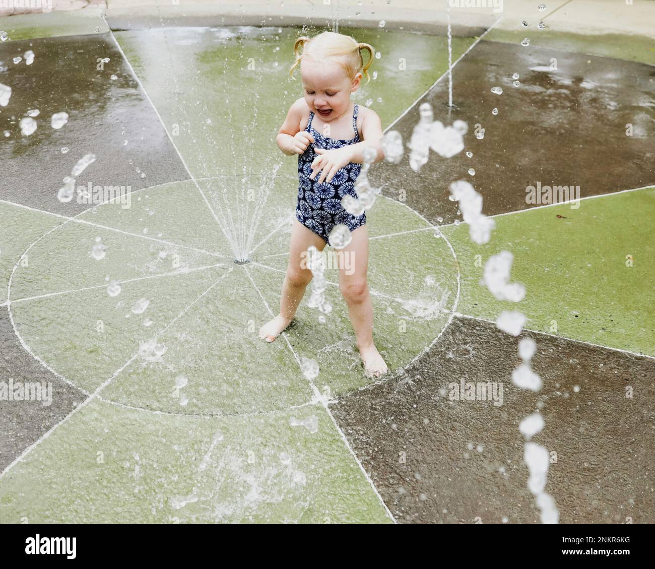 Young girl playing in water fountain in park Stock Photo - Alamy