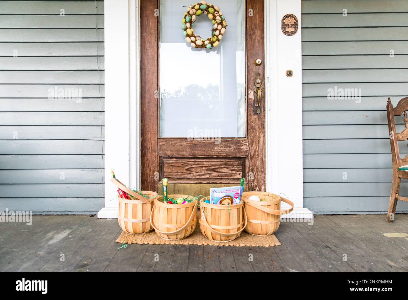 Four Easter baskets lined up on porch in front of front door Stock Photo