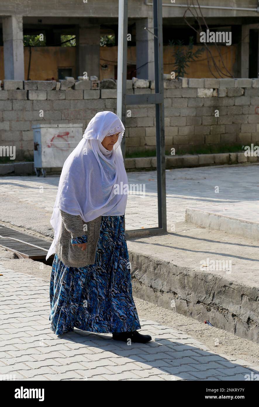 OVAKENT,HATAY,TURKEY-DECEMBER 10:Unidentified Older Uzbek  Woman with White hijab walking down the street. December 10,2016 in Ovakent, Hatay, Turkey Stock Photo