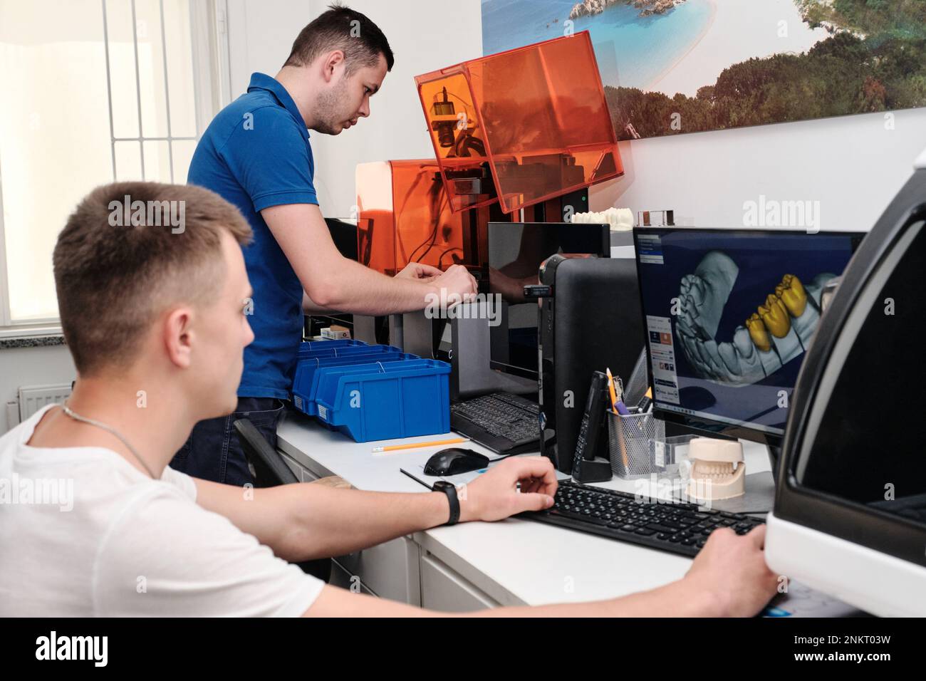 Two dental technicians working in a dental laboratory. 3D modeling of the crown in the dental lab. Stock Photo