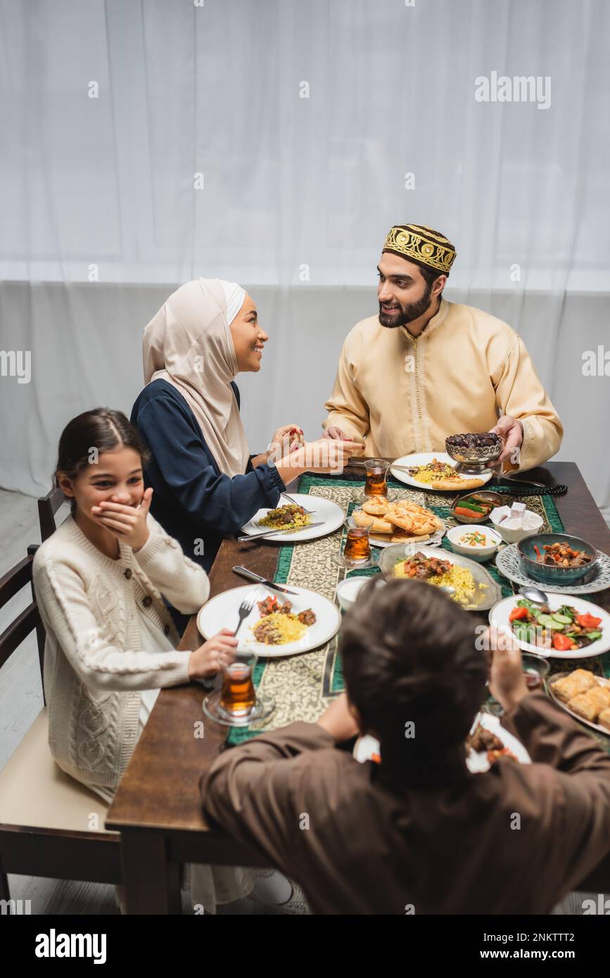 Muslim parents talking near children and ramadan food at home,stock image Stock Photo