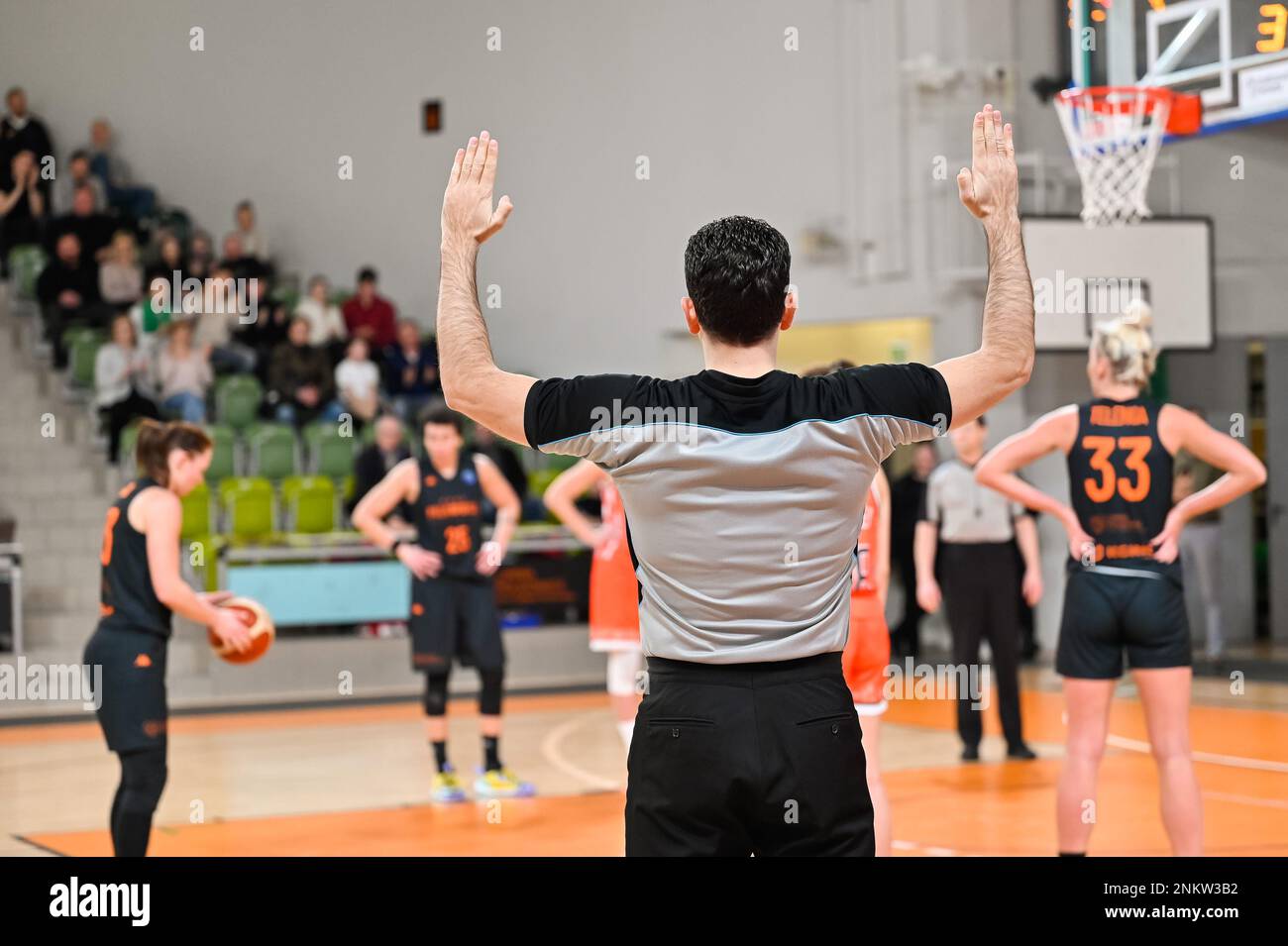 Man referee shows the free throw with his hands. In the background players. Stock Photo