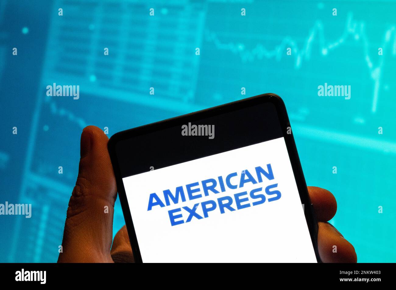 China. 15th Feb, 2023. In this photo illustration, the American multinational financial services corporation and credit card business American Express logo is seen displayed on a smartphone with an economic stock exchange index graph in the background. Credit: SOPA Images Limited/Alamy Live News Stock Photo