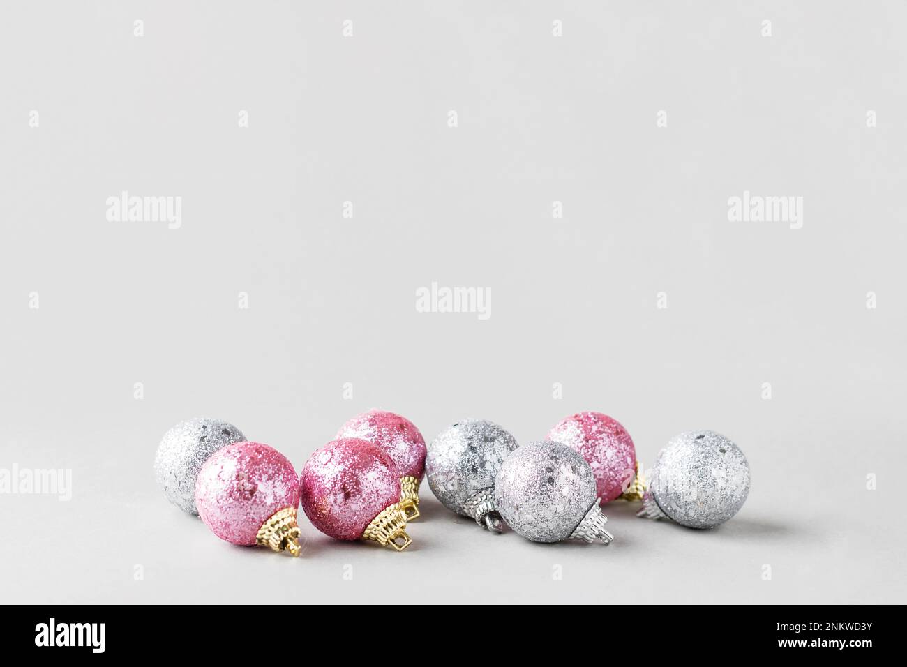 Pink and silver christmas balls isolated on gray background. Christmas and New Year background greeting card concept. Selective focus. Copy space for Stock Photo