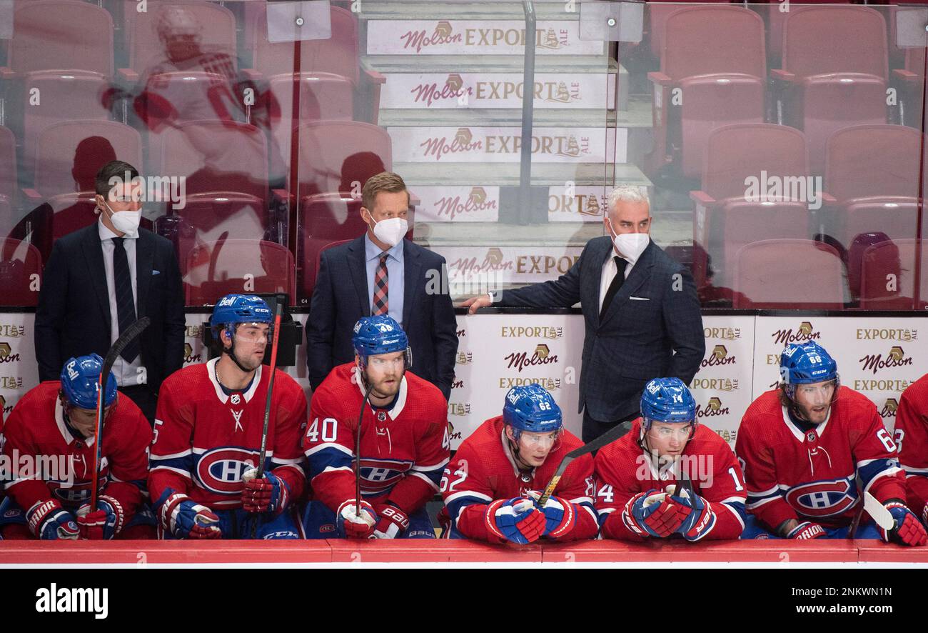 Montreal Canadiens players and coaches look on from the bench during the third period of an NHL
