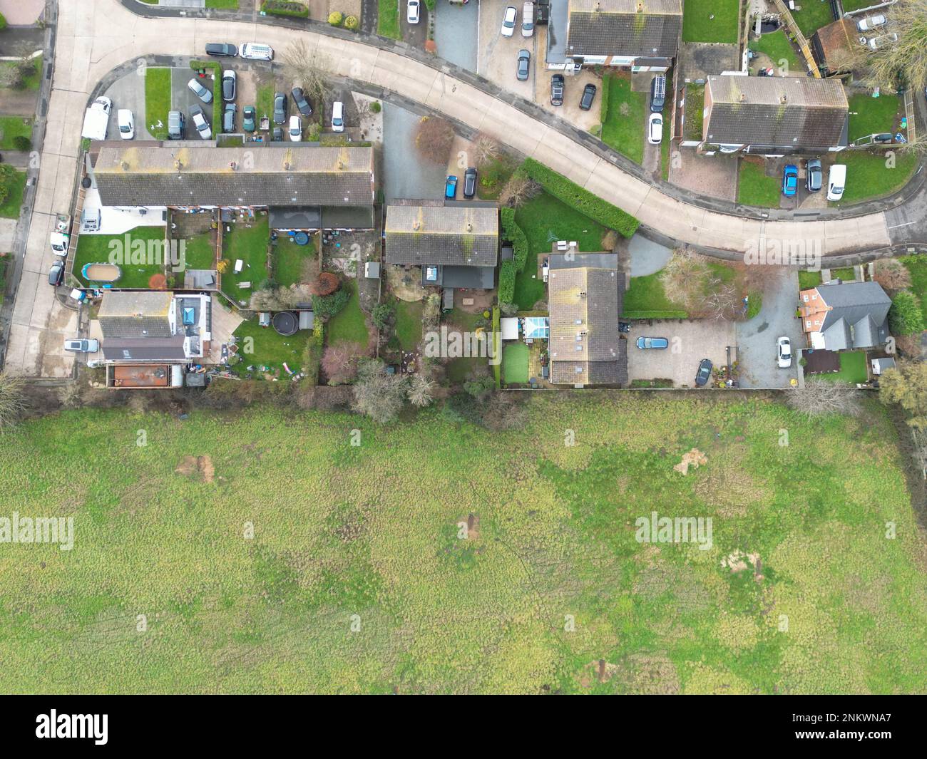 Aerial view of a small rural housing estate in the UK. The adjacent field may soon be developed on for my housing. Stock Photo