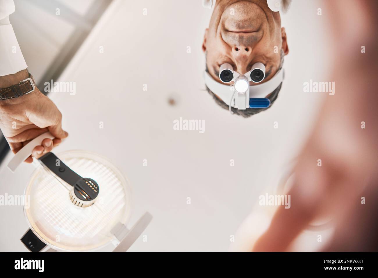 Eye exam, flashlight and face of optometrist looking down to patient