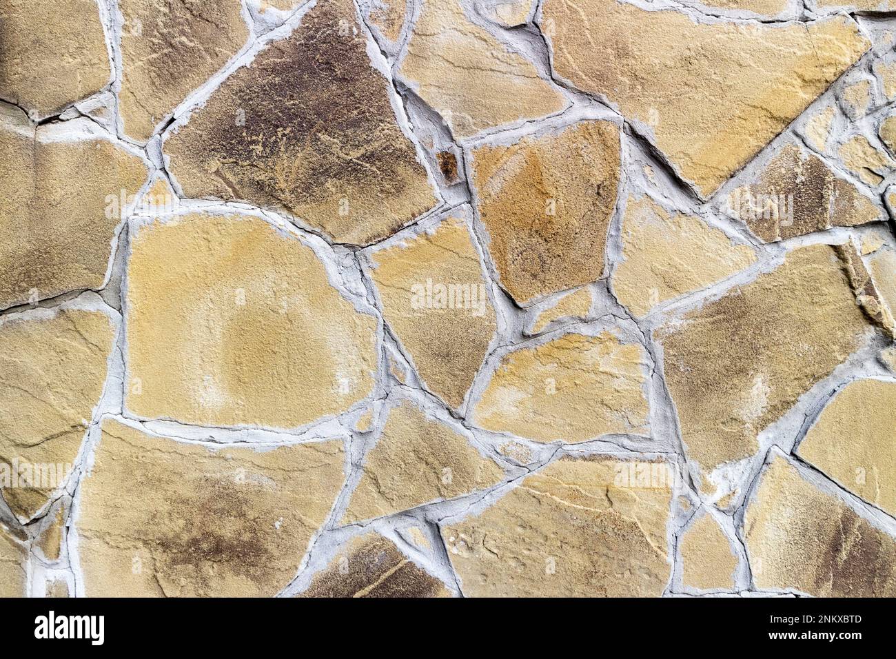 Wall with irregularly shaped brown tiles. Stock Photo