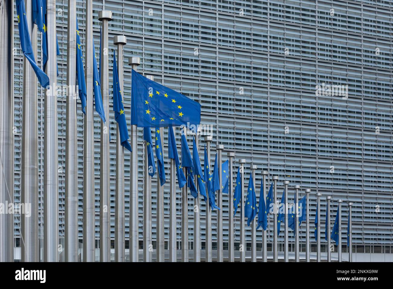 BRUSSELS, Belgium - February 23, 2023: Berlaymont building, seat of the European Commission, with flags blowing in the wind in front of it Stock Photo