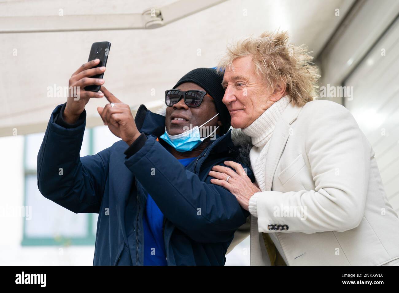 Sir Rod Stewart takes a selfie with Omarie Ryan, who received an MRI scan on his left knee). The musician is meeting patients and medics at the Princess Alexandra Hospital in Harlow, Essex, after he called a phone-in segment on live Sky News in January, and offered to pay for people to have hospital scans, amid the rising number of people on NHS waiting lists. Picture date: Friday February 24, 2023. Stock Photo