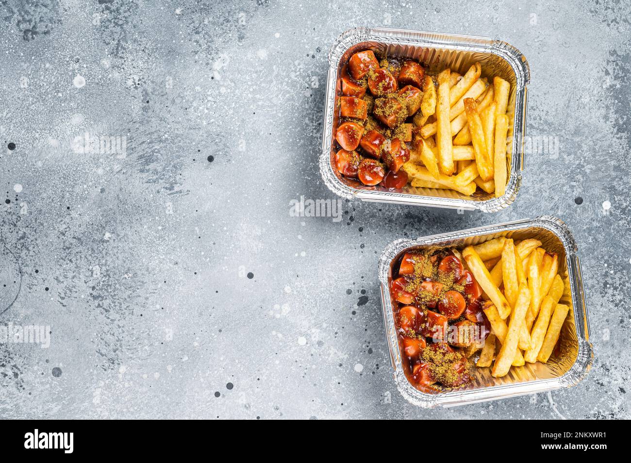 Traditional German currywurst with french fry served take away. Gray