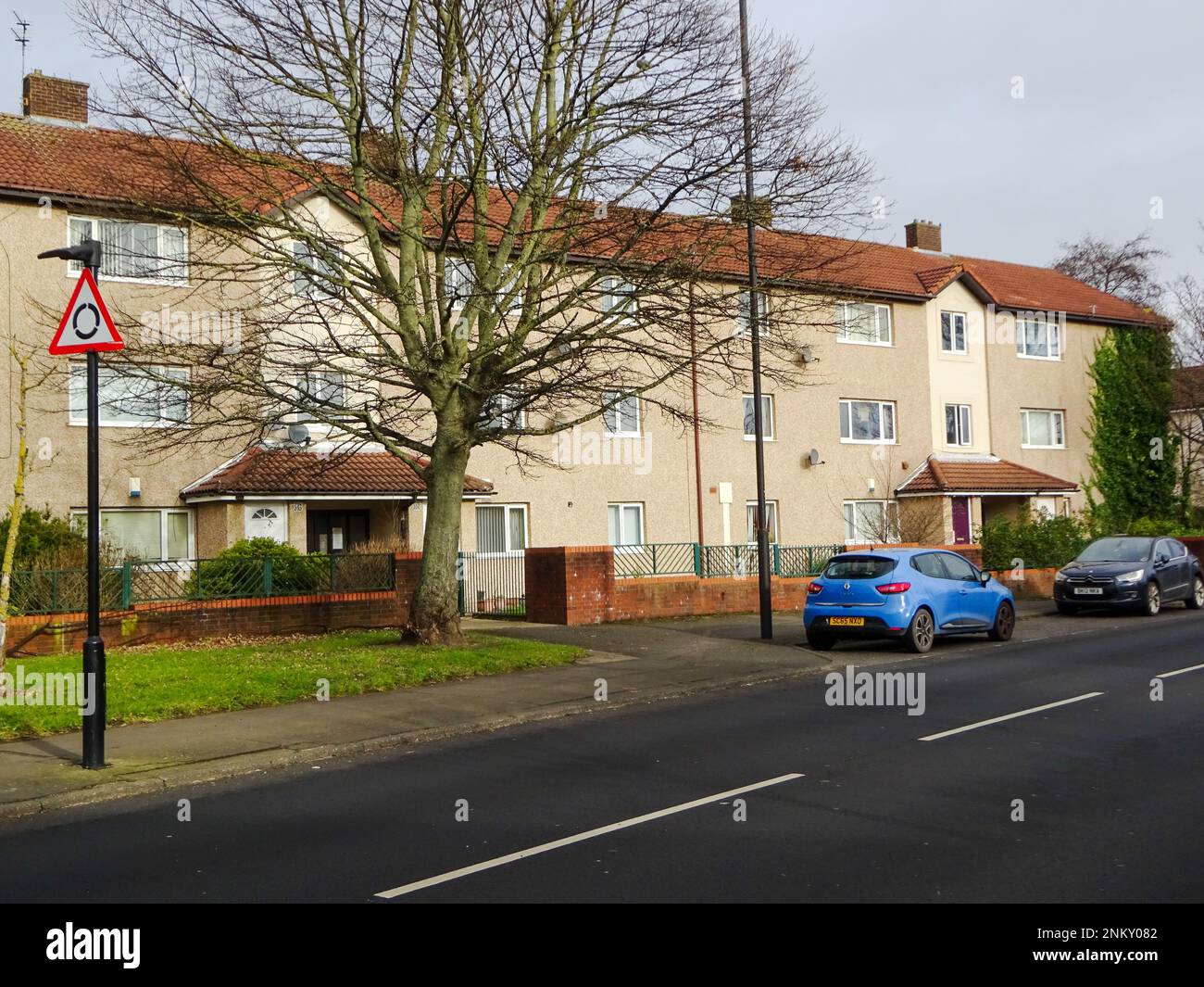 A landscape of a road with cars parked on it on a gloomy day in