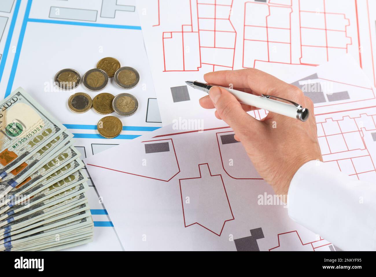 Cartographer with money drawing cadastral map, closeup Stock Photo