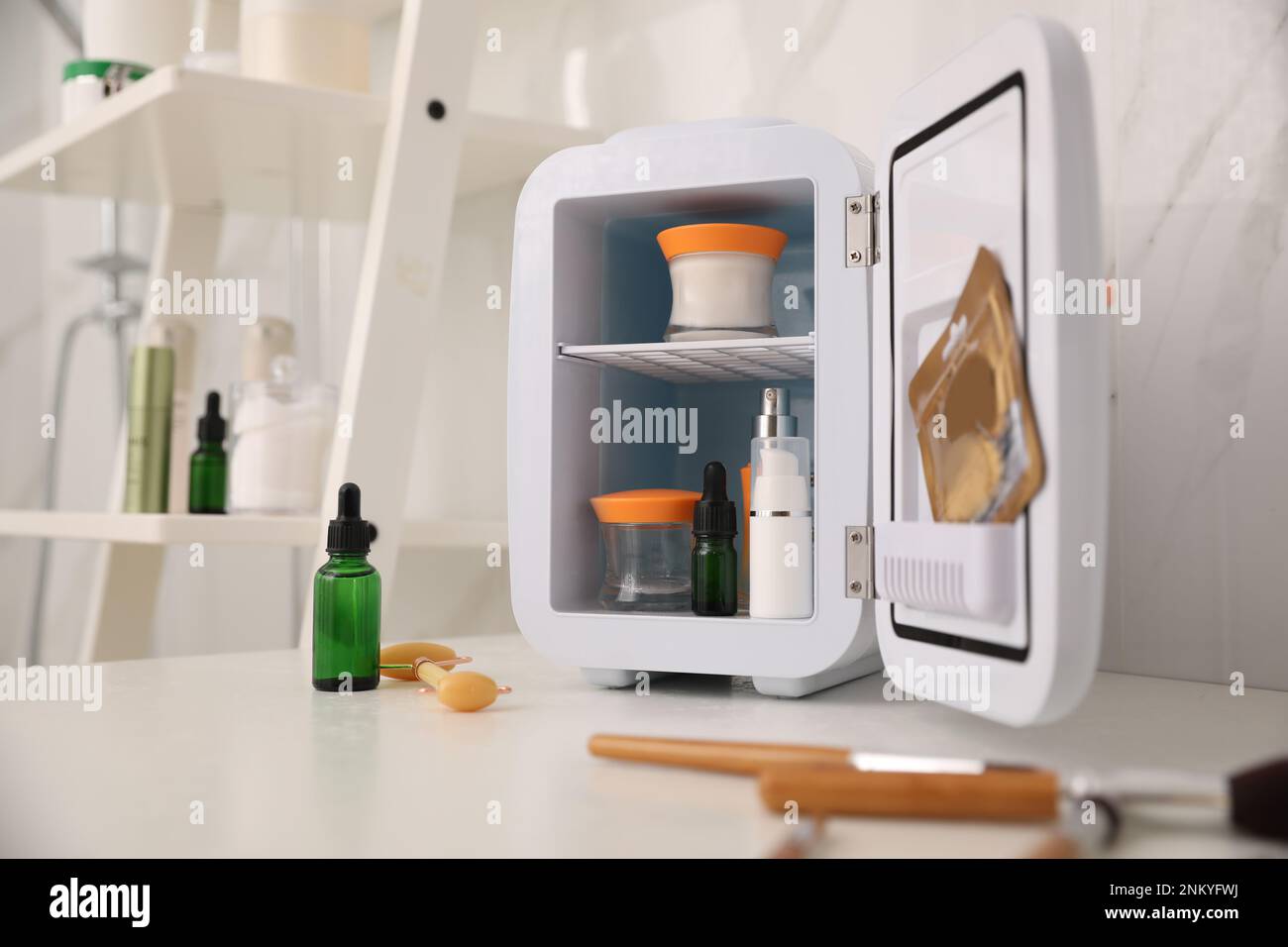 Mini refrigerator for cosmetic products on counter in bathroom Stock