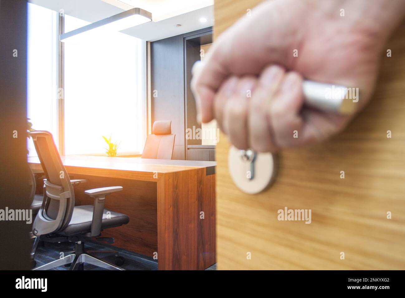 A closeup of a hand grabbing a door knob of a business room at office