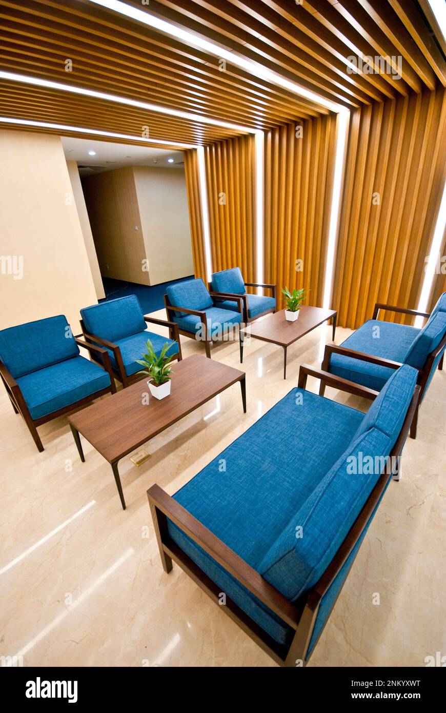 An interior shot of a modern living room, featuring two blue armchairs