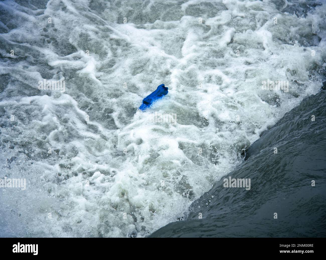 A waterfall and an empty plastic bottle tumbling in rough water