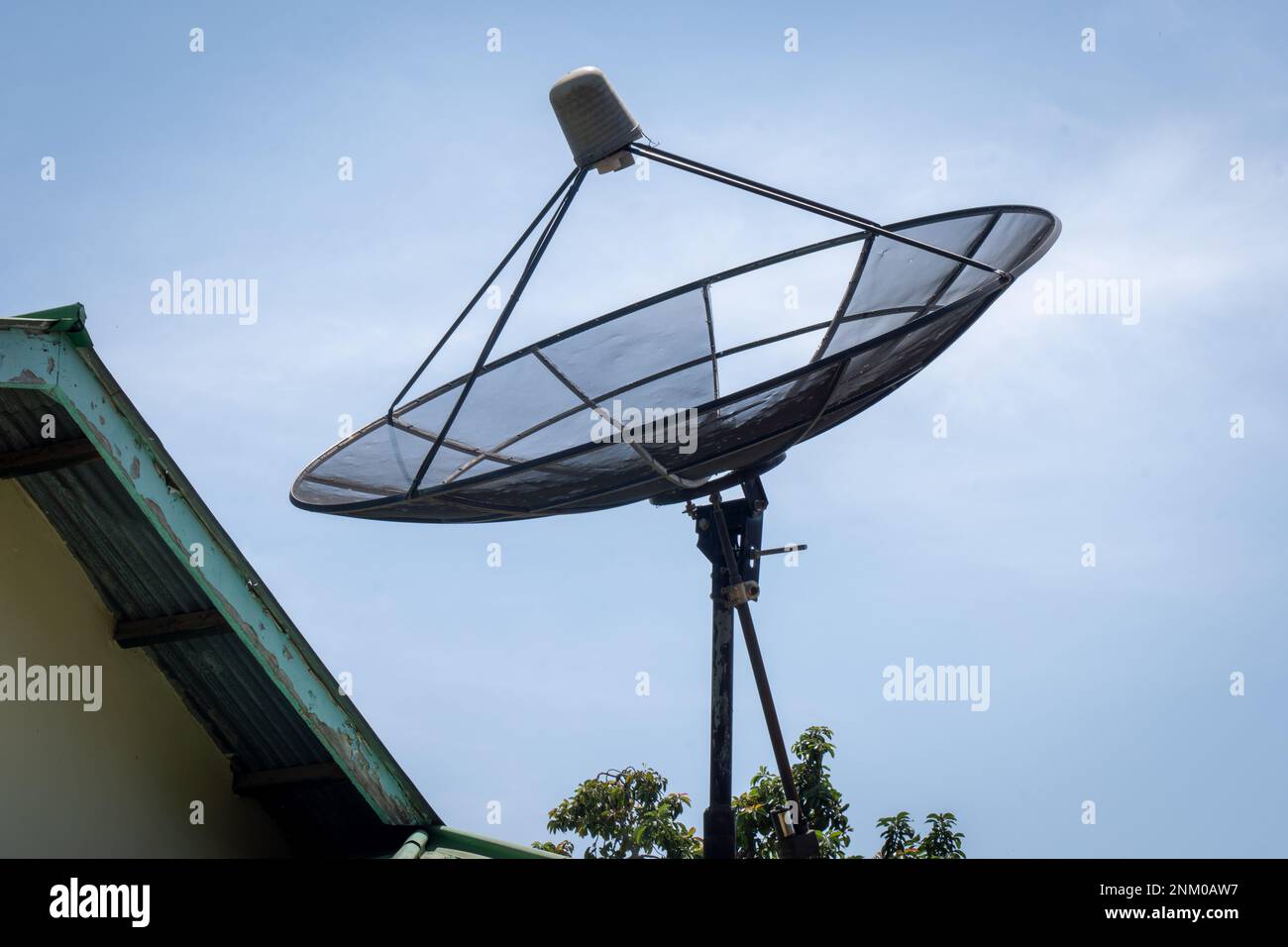 Big C-Band Satellite dish on roof of a house. Option to get free cable TV signal. Stock Photo