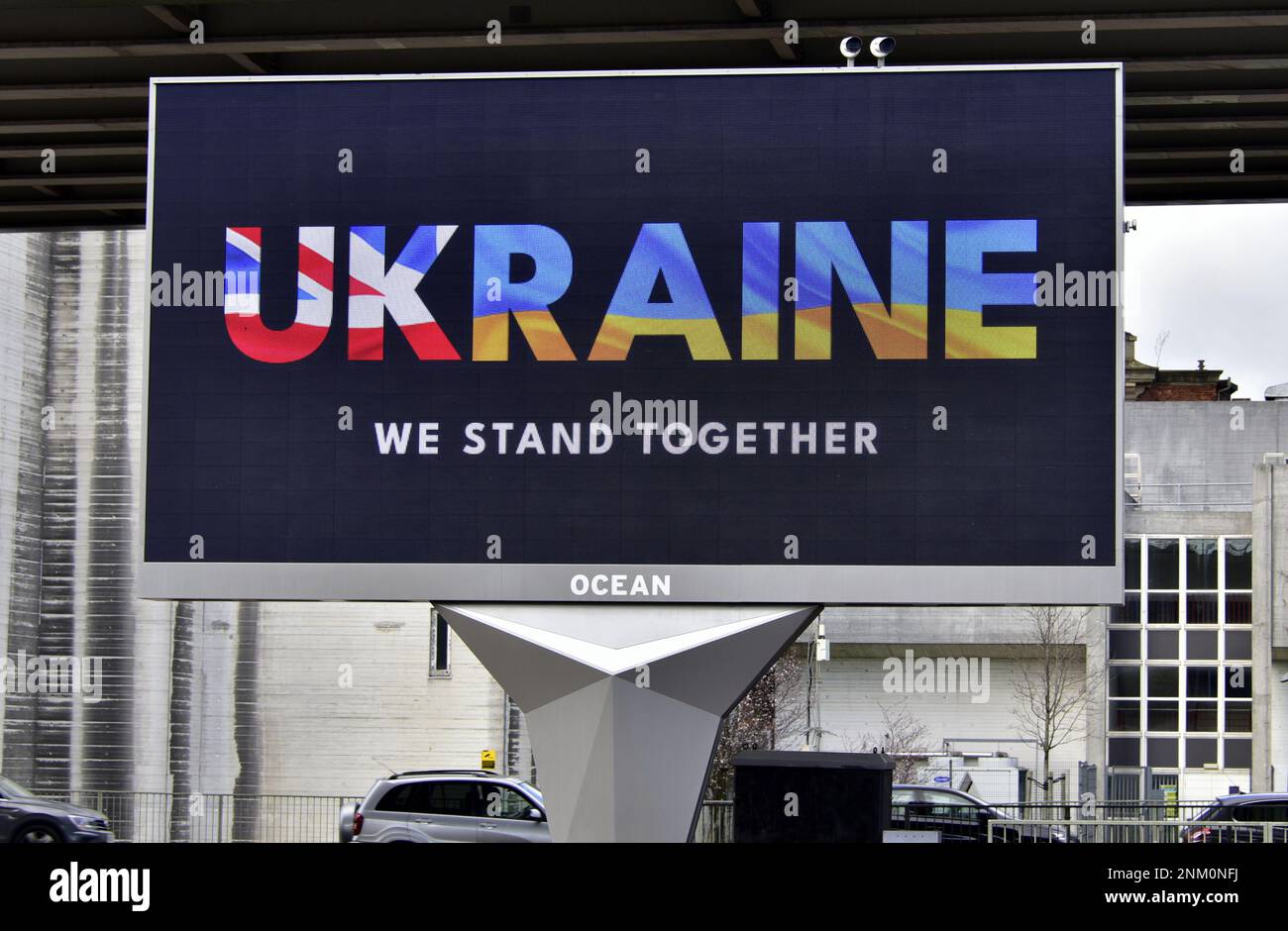 An electronic billboard in Manchester, UK, on 24th February, 2023, marks the first anniversary of Russia's illegal invasion of Ukraine, with UKRAINE in British and Ukrainian flag colours and a 'We Stand Together' message. Stock Photo