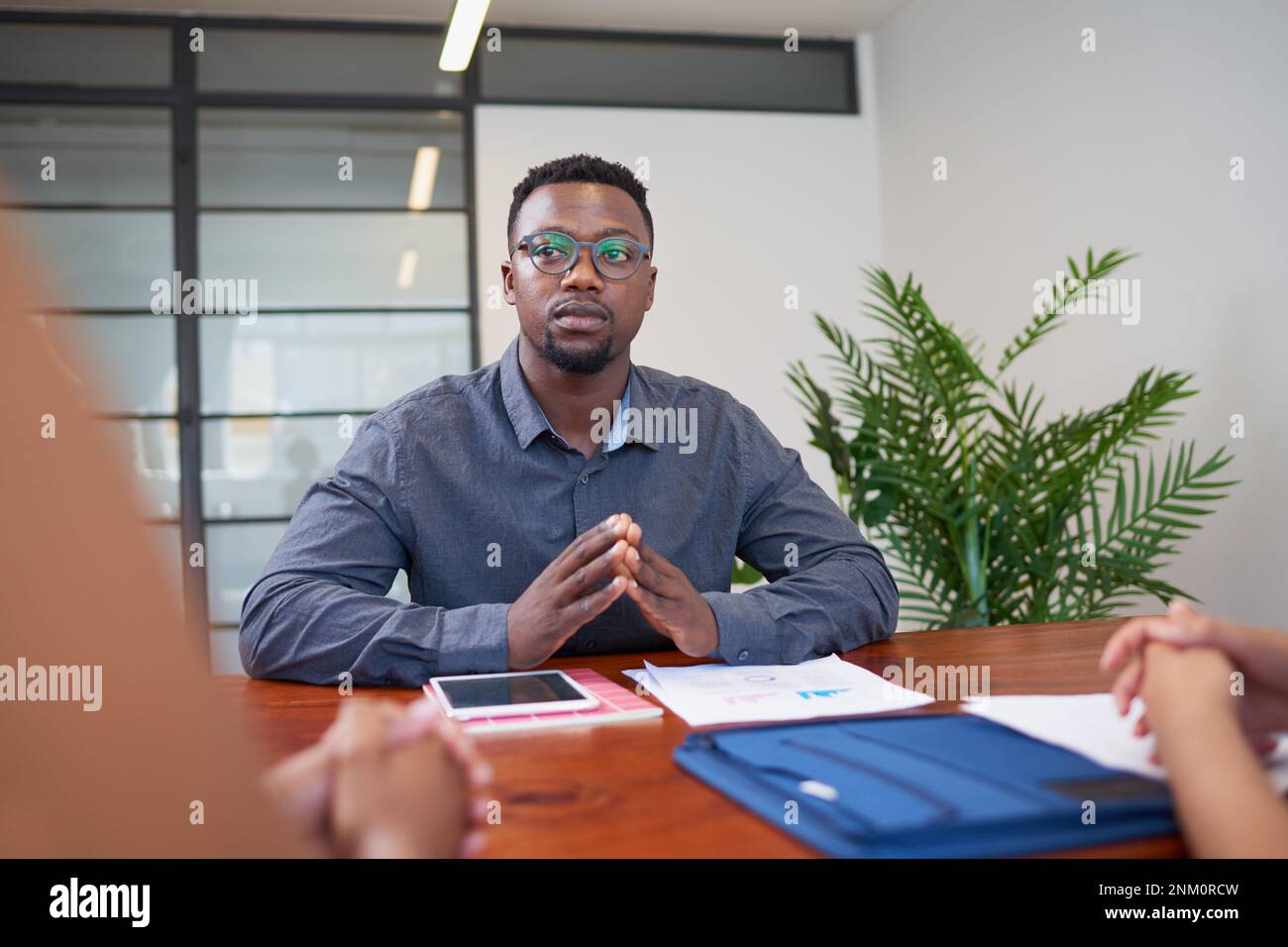 Serious Black businessman during boardroom meeting, considering proposal Stock Photo