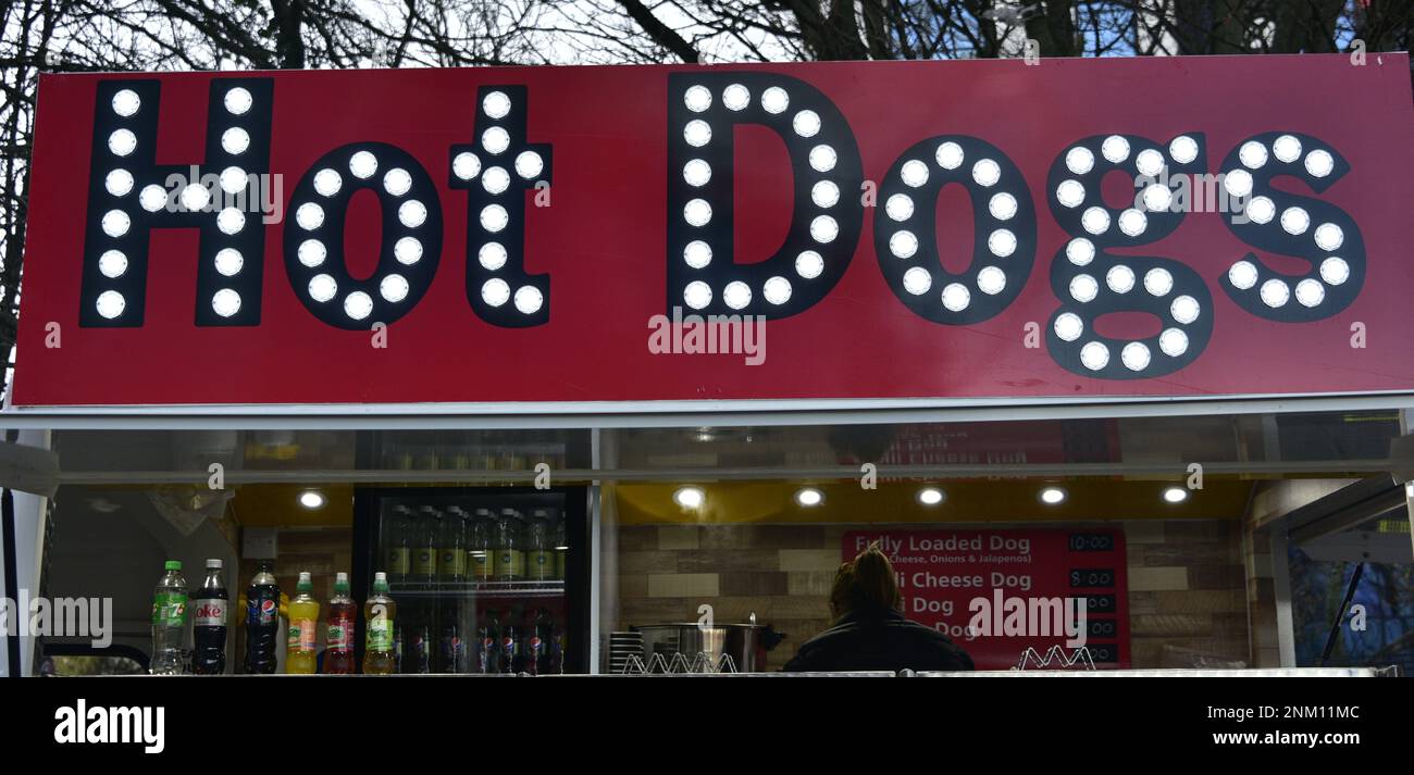 Illuminated 'Hot Dogs' sign on a stall selling hot dogs, a food