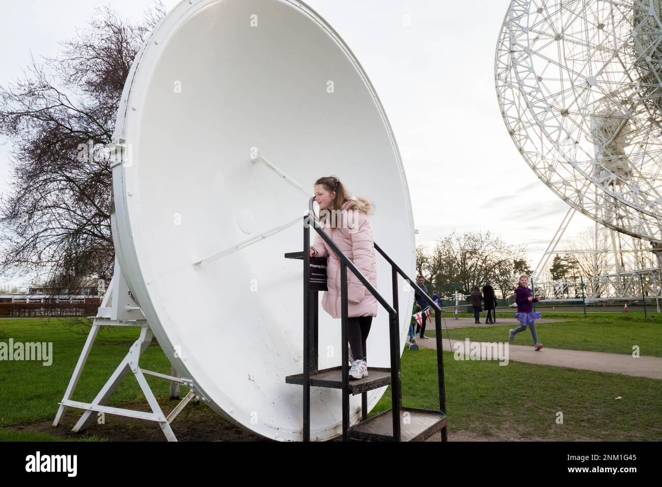 Kids / girls / children / child listen and speak at the Whispering Dish / Dishes which act as an acoustic mirror to transmit and focus sound waves. (133) Stock Photo