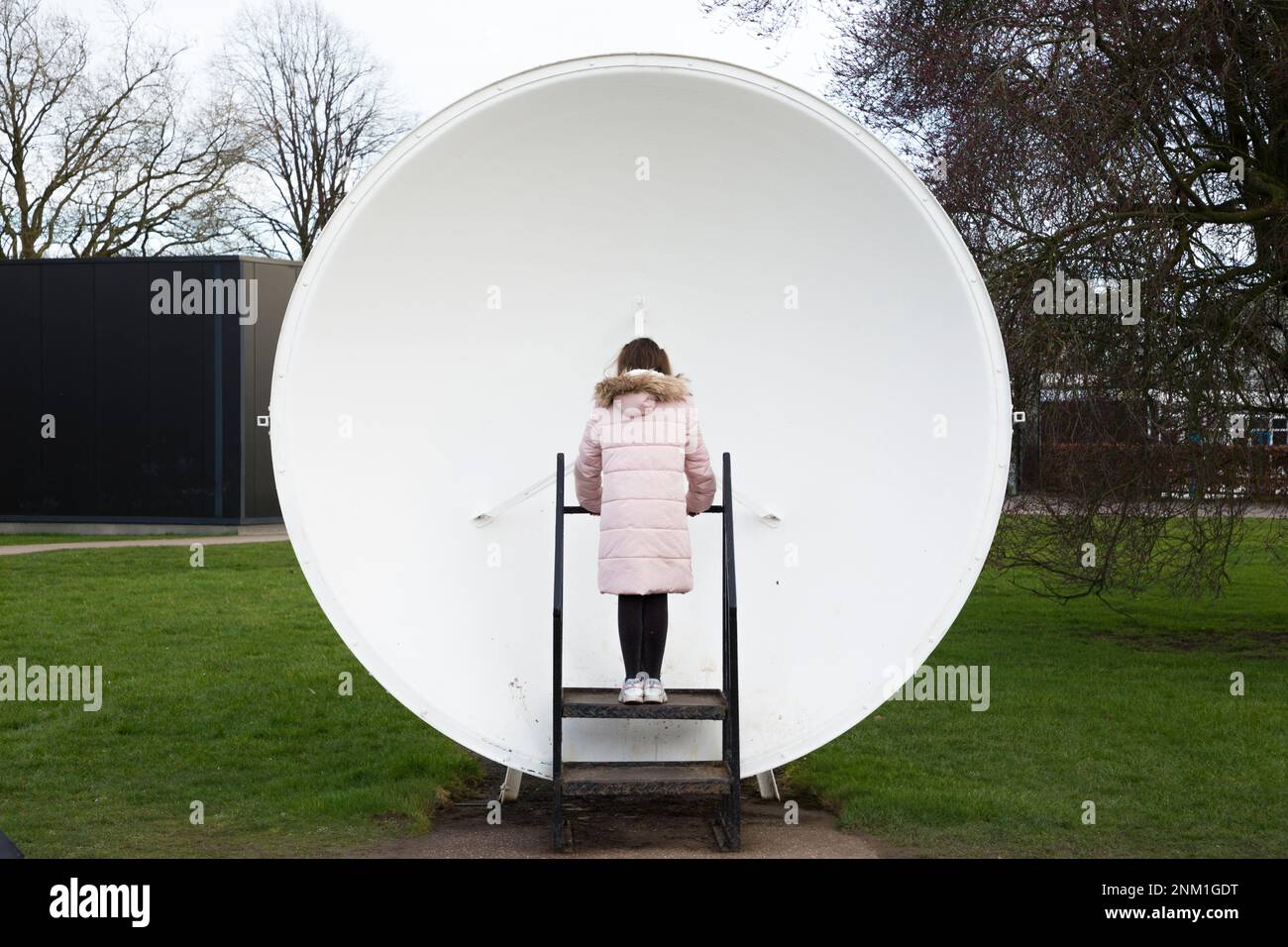 Kids / girls / children / child listen and speak at the Whispering Dish / Dishes which act as an acoustic mirror to transmit and focus sound waves. (133) Stock Photo