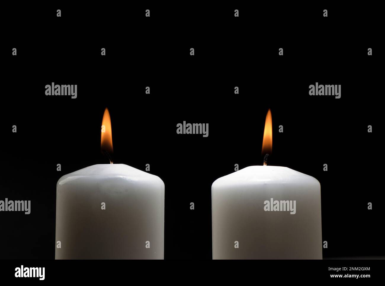 Two burning candles on a black background, couple Stock Photo