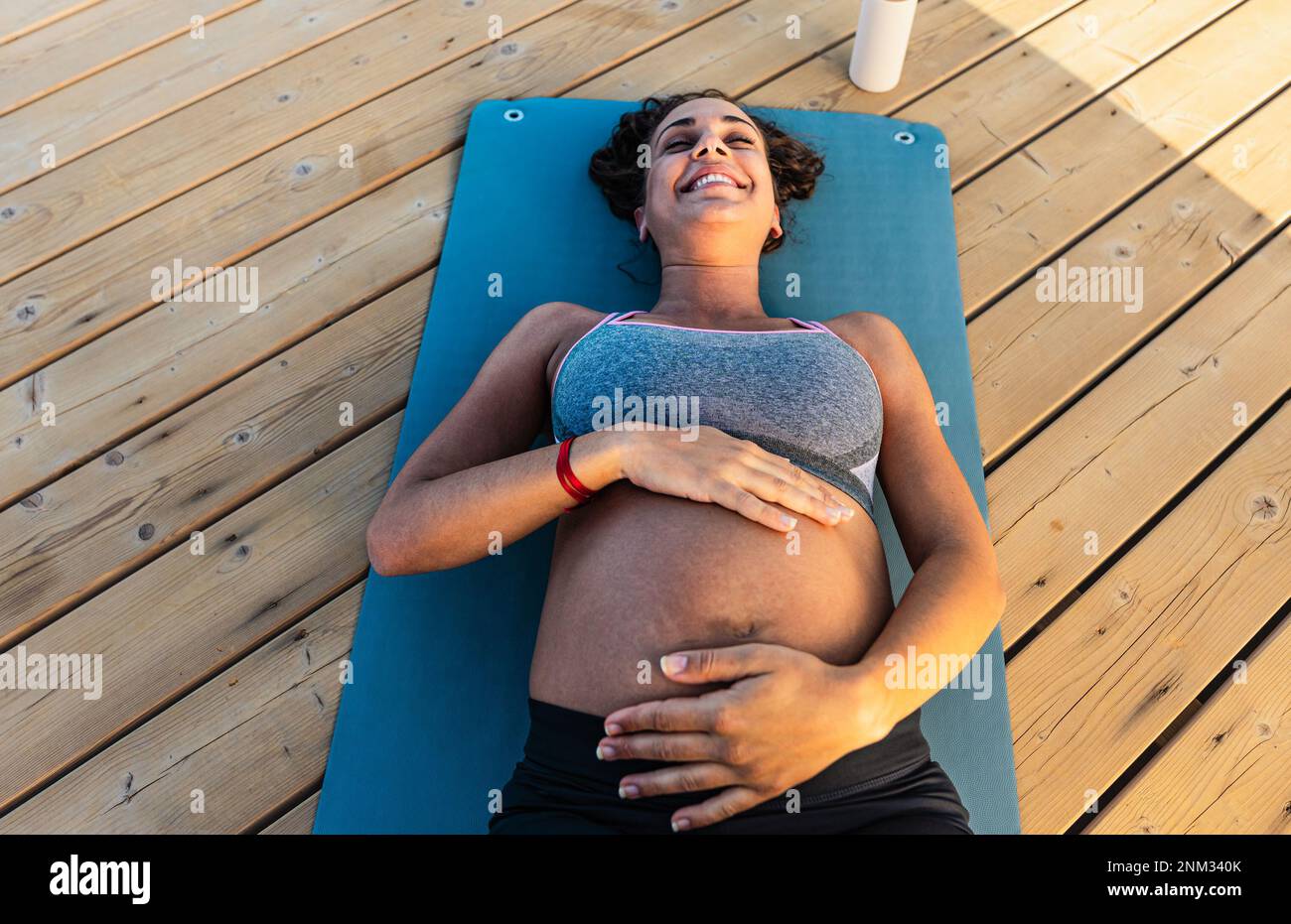 Top view of happy pregnant woman caressing her belly outdoor - Health lifestyle and maternity concept Stock Photo