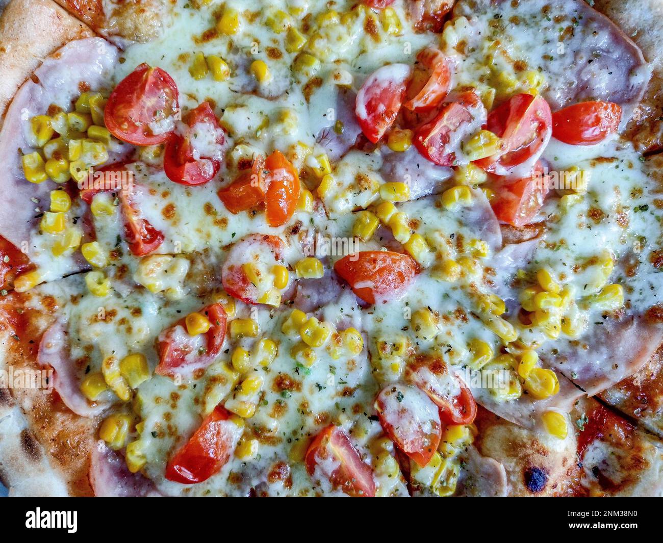 pizza with ham, mozzarella, corn and tomatoes Stock Photo