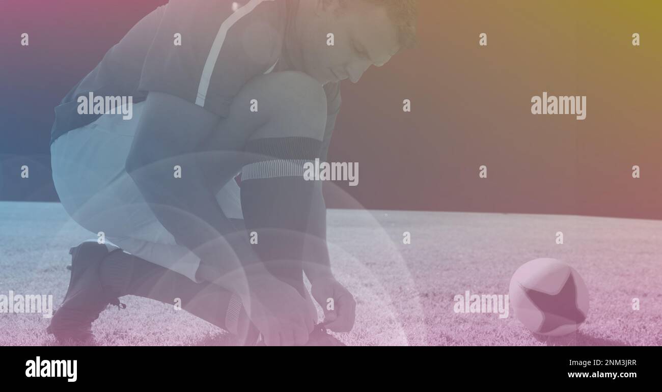 Composition of male rugby player tying shoe lace with rugby ball on