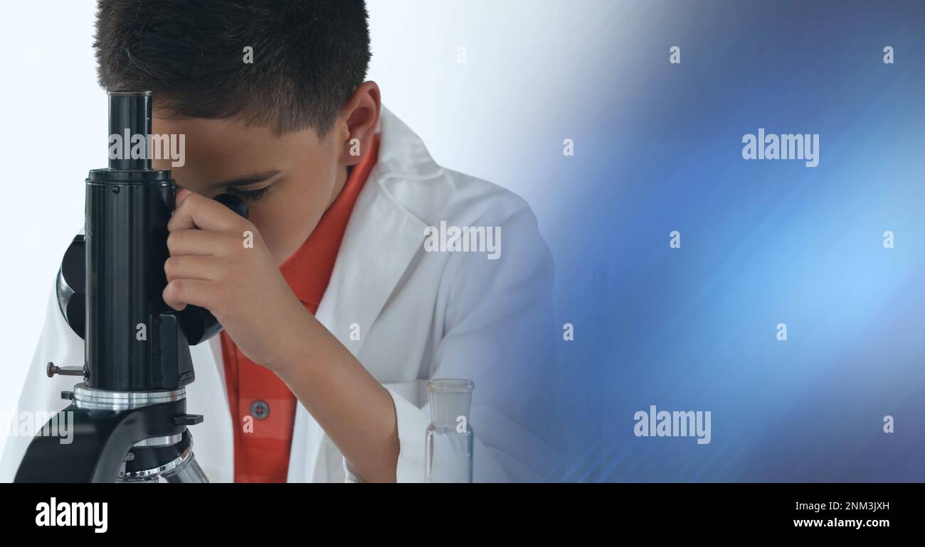 Composition of boy using microscope in science class, with blue blurred ...