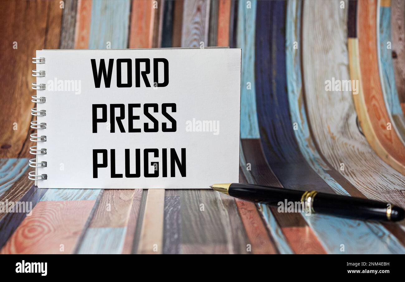 On a vintage background, a white notebook with the text WORD PRESS PLUGIN Stock Photo