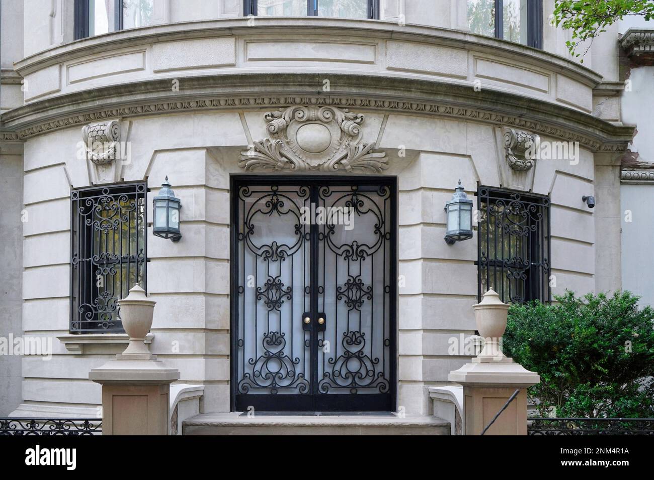Entrance to elegant baroque style apartment building or townhouse, with decorative and protective iron grill on windows Stock Photo