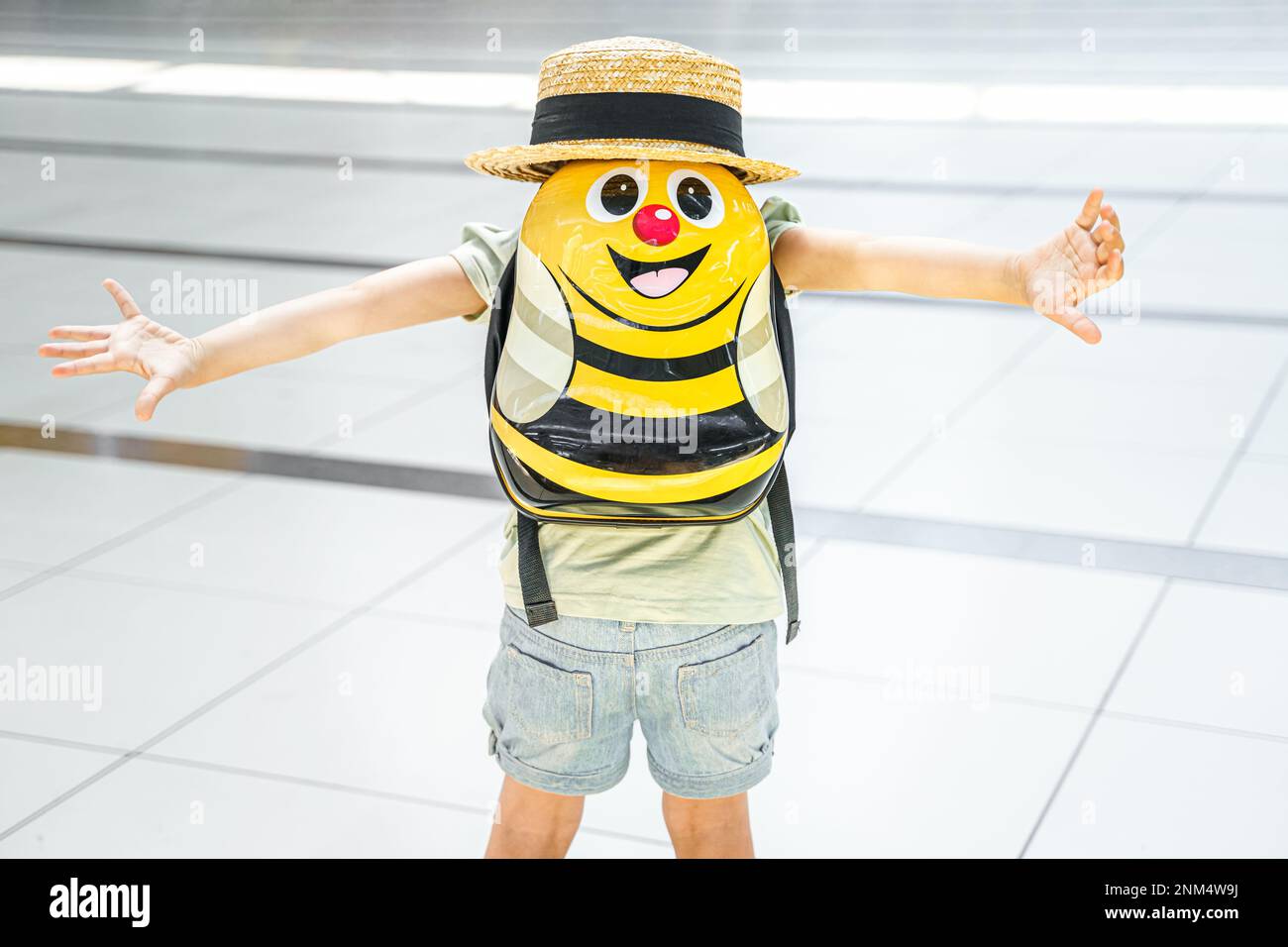 Girl with big funny backpack, bag in airport terminal. Waiting for