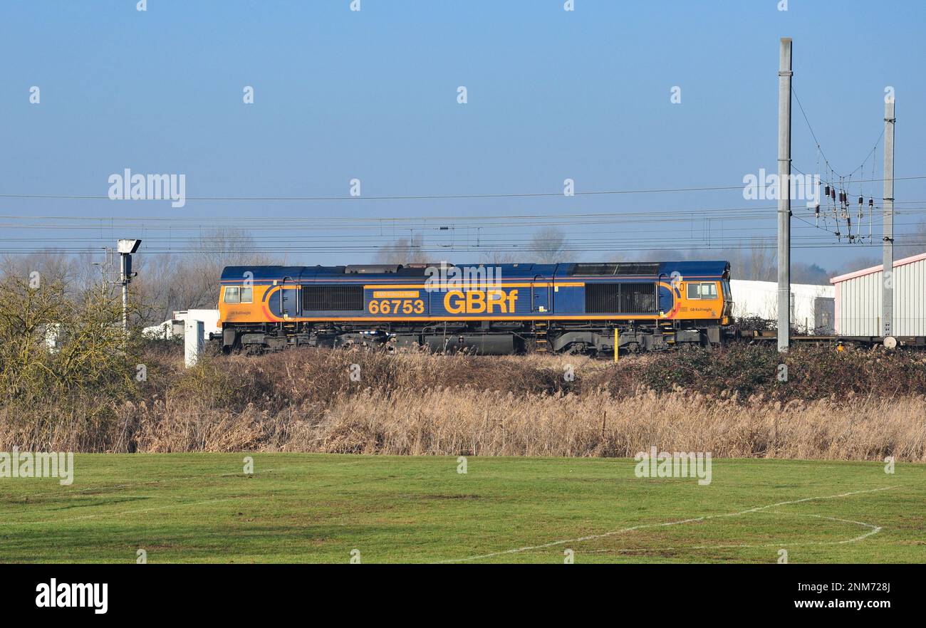 Class 66 locomotive heads container wagons south from Ely, Cambridgeshire, England Stock Photo