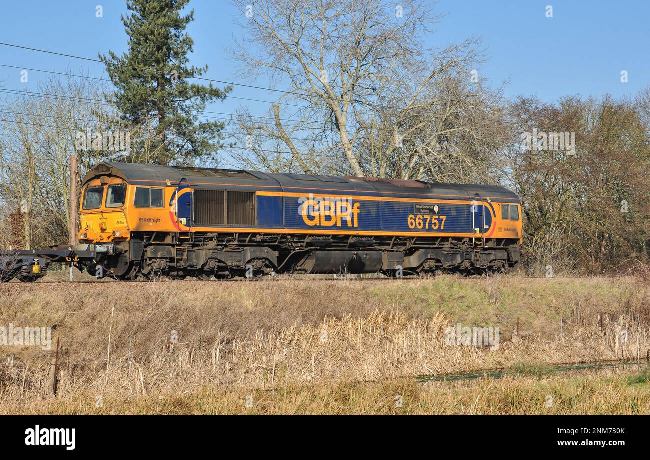 Class 66 locomotive heads container wagons north from Ely, Cambridgeshire, England Stock Photo