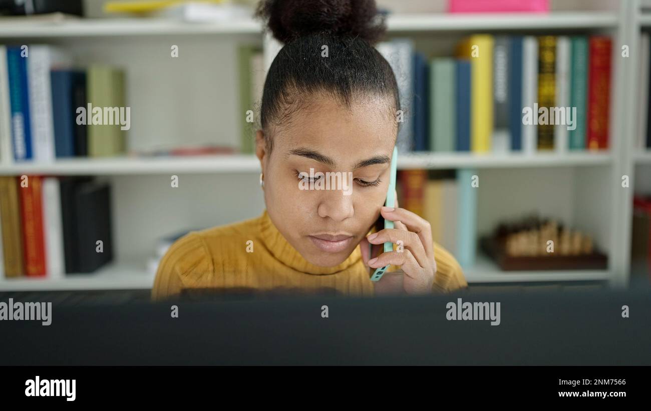 Young african american woman student using computer speaking on the ...