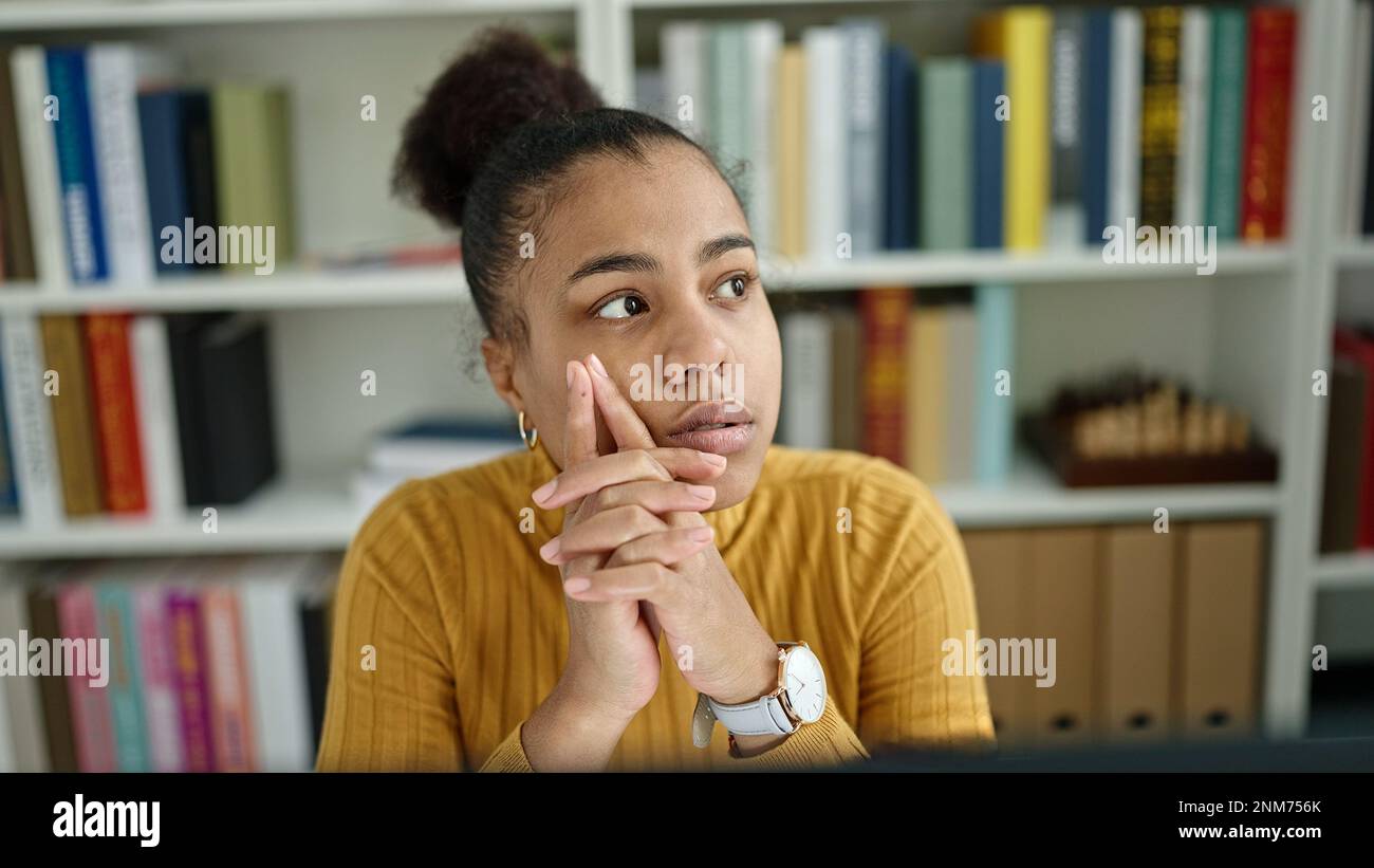 Young african american woman student using computer thinking at the ...