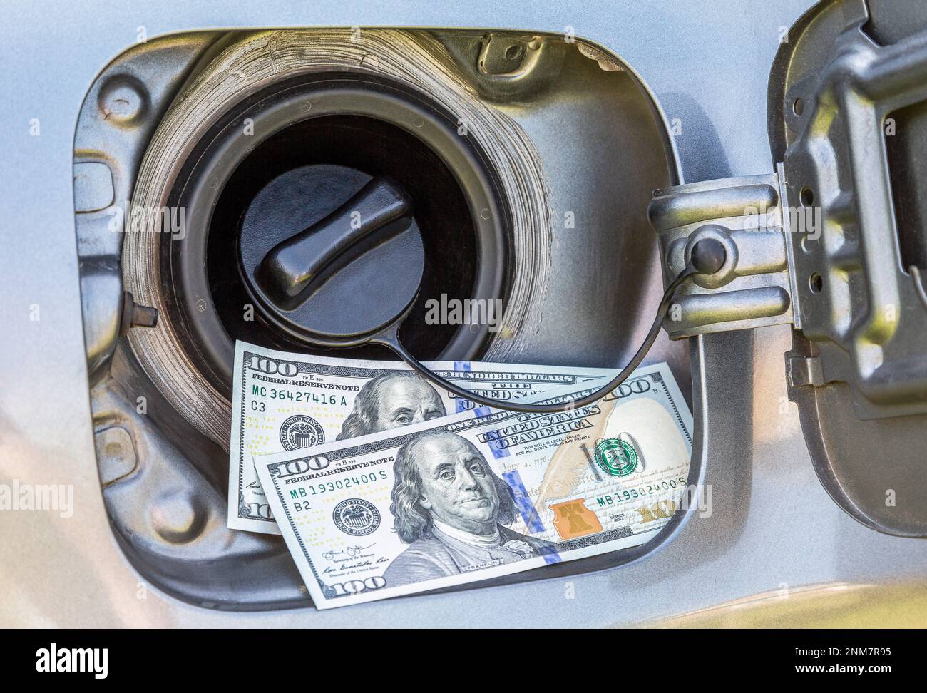 Two hundred american dollar notes attached to an open fuel tank, symbol
