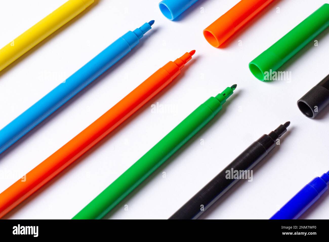 https://c8.alamy.com/comp/2NM7WF0/markers-of-different-colors-at-an-angle-on-a-white-background-caps-separately-2NM7WF0.jpg