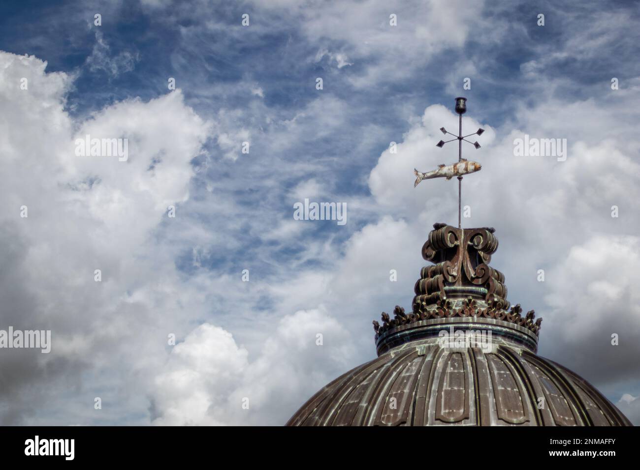 Copper dome with fish weather vane against cloudy sky Room for copy Stock Photo