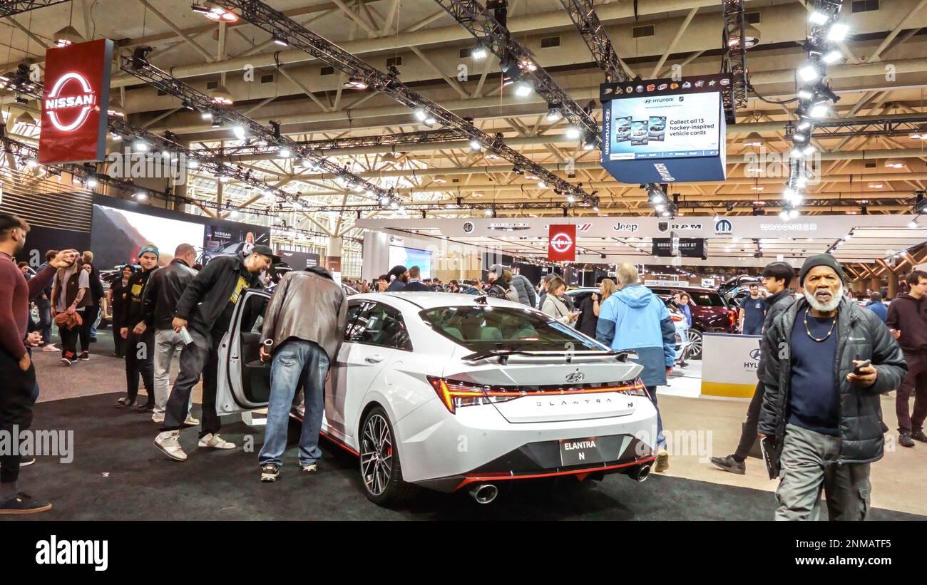 Crowds looking at new car models at Auto show. National Canadian Auto Show with many car brands. Toronto ON Canada Feb 19, 2023 Stock Photo
