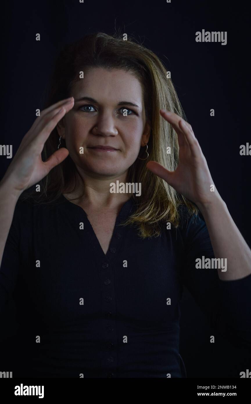 portrait of a beautiful blonde woman who with a gesture of her hands says she is full of work Stock Photo