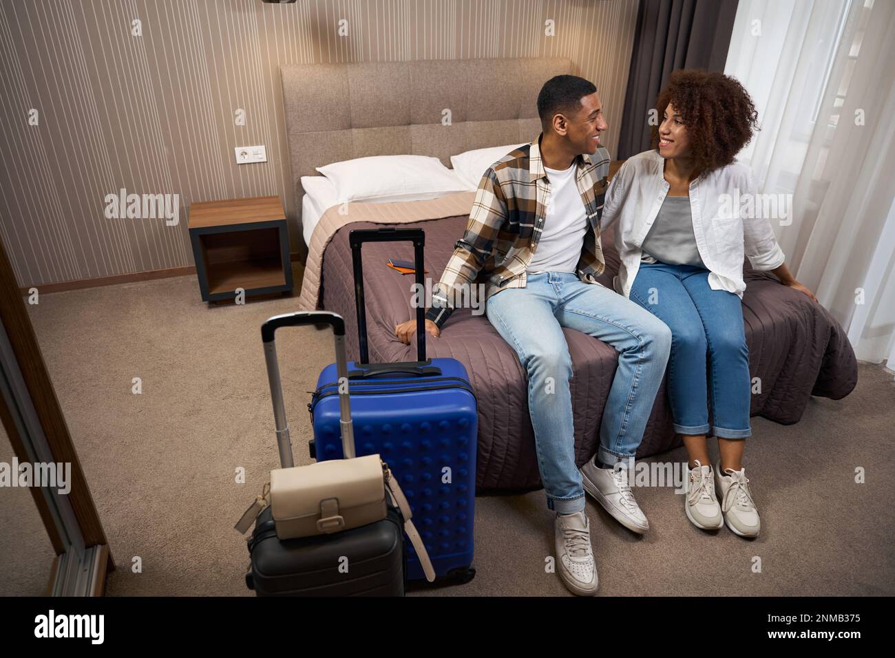 Happy newlyweds arrived at the hotel, around suitcases Stock Photo - Alamy